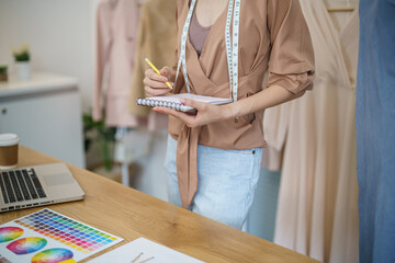 Tailor woman working in tailor shop Stylish Fashion designer tailor in workshop studio designing new collection Dressmaking and Creative.fashion collection.