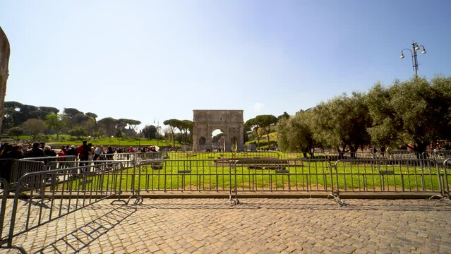 Triumphal arch in Rome, Italy. Tourists walking nearby. Panoramic shot