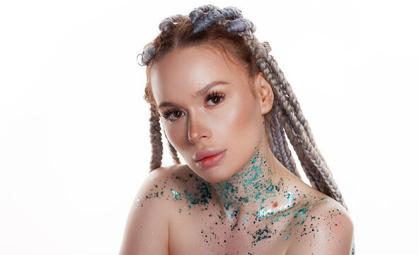 Beauty portrait of lovely young woman with glitter sparkles on her face, neck and shoulders over white background