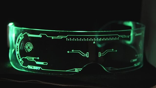 Futuristic glasses with various patterns smoothly change different colors in the dark close-up