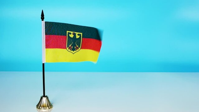 Government flag of Germany with an eagle. The flag of germany flutters in the wind on a blue background.