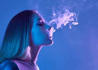 beautiful woman smokes releasing thick smoke in neon light