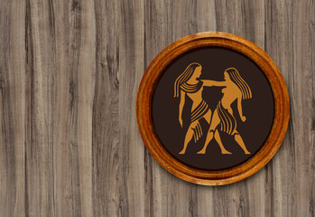 The sign of the zodiac Gemini in a round frame on the wall of the boards