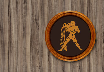 The sign of the zodiac Aquarius in a round frame on the wall of the boards