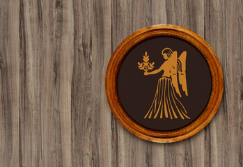 The sign of the zodiac Virgo in a round frame on the wall of the boards