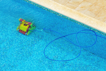 Robotic swimming pool cleaner in operation at the bottom of the pool