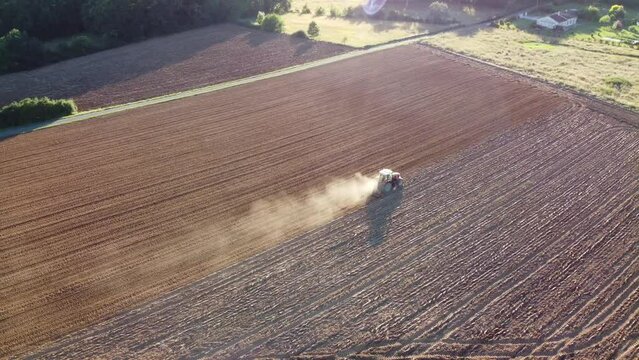 Engin agricole dans un grand champ labour&eacute; travaillant dans un environnement sec et aride