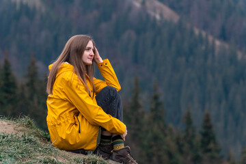 Portrait of beautiful caucasian woman with long hair on hillside on forest background. Lifestyle of tourist girl