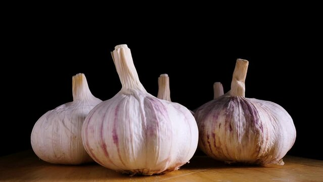 fresh garlic on wooden board, rotation closeup