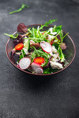 green salad cheese and vegetable radish, tomato, cucumber, green lettuce mix healthy meal food snack on the table copy space food background rustic top view keto or paleo diet veggie vegetarian food