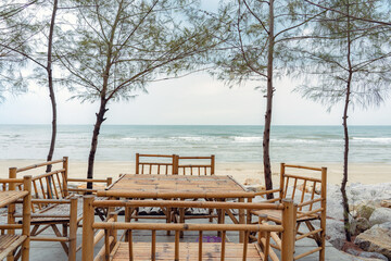 bamboo natural chairs wooden tables. cafe restaurant table on ocean beach sea view. Summer and vacation concept.