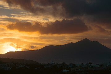 Houses of Procida in magic sunset with the island of Ischia in the background.