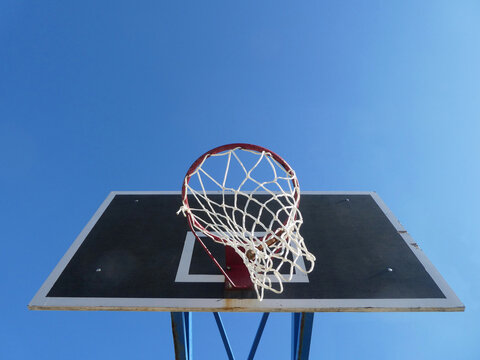low angle view of basketball hoop against blue sky - Powered by Adobe