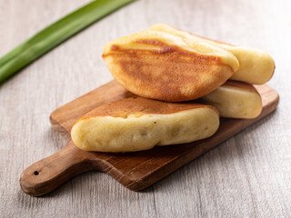 Kue Pukis, is an Indonesian traditional cake served on a wooden tray. Pukis is made of a wheat flour-based batter and cooked in a special mold pan similar to muffin tin.