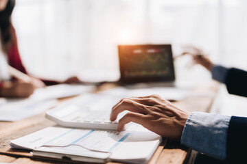 startup business, business advisor using calculator to planning finance investment teamwork paperwork audit and discussing marketing, profit of company in meeting room, stock market chart concepts