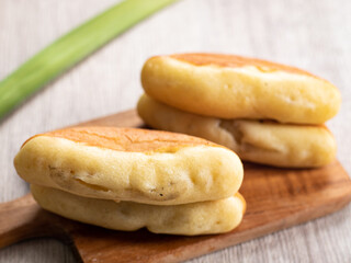 Kue Pukis, is an Indonesian traditional cake served on a wooden tray. Pukis is made of a wheat flour-based batter and cooked in a special mold pan similar to muffin tin.