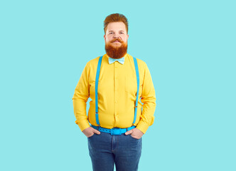 Portrait of extravagant confident and stylish chubby funny man on light blue background. Serious...