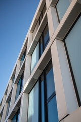Facade of a multi-story building with white and blue elements and a blue sky