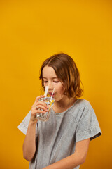 Pretty teen girl, child with a fresh glass of water isolated