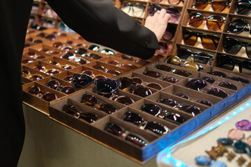 bustling sunglasses stall at a local fair, exhibiting an array of colorful and unique eyewear designs, catering to various tastes and styles for people enjoying the event.