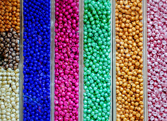 Many hocolates wrapped in colorful foil for sale in candy shop. Abstract background colorful candies