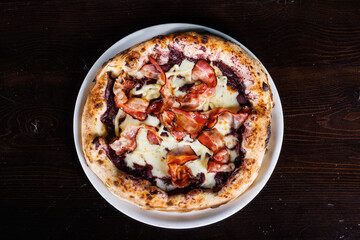 Pizza napoletana gourmet con fior di latte, crema di radicchio, pancetta croccante e basilico...