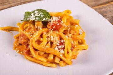 Piatto di Pasta con salsiccia, pomodori, ricotta e formaggio servito come primo piatto in un ristorante