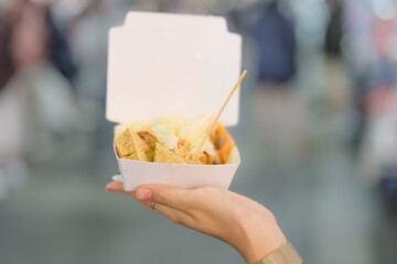 woman hand holding Stinky Tofu at night market, famous Taiwanese Street Food of Taiwan. exotic food in local market
