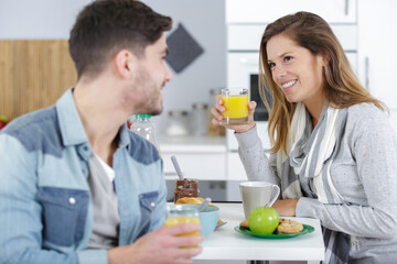 young couple chatting while having breakfast at home