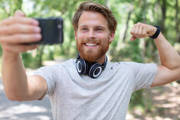 young man clicking selfie while standing at forest