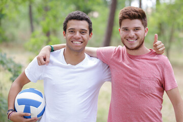 cheerful friends after game with ball outdoors