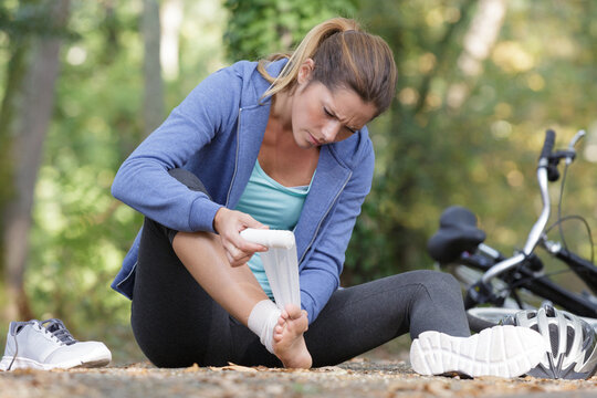 woman bandaging her injured knee