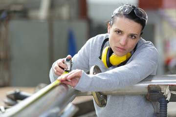 woman with tape measure ready to cut metal