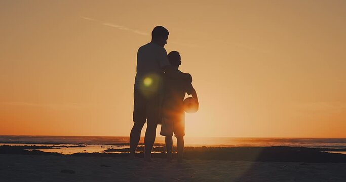 Father and Son playing football on the beach, family fun outdoors players in soccer in dynamic action have fun playing football, summer day under sunlight.