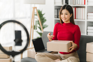 Starting Small business entrepreneur SME freelance,Portrait young woman working at home office, BOX,smartphone,laptop, online, marketing, packaging, delivery, SME, e-commerce concept