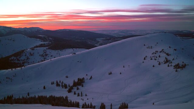 Scenic deep purple orange sunset mid winter deep backcountry atop mountain pass pan left at Vail Pass Colorado Rocky Mountains