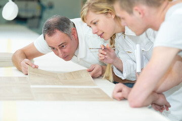 tiler showing apprentice how to place boards
