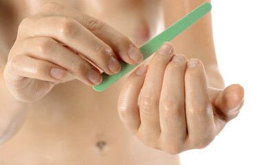 Well-groomed young healthy woman at manicure filing fingernails with nail file - obrazy, fototapety, plakaty