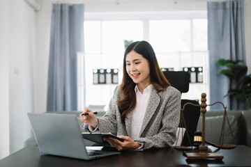 Beautiful asian woman lawyer working and gavel, tablet, laptop in front, Advice justice and law concept. in office.