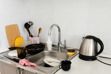 Many dirty dishes in kitchen. House cleaning concept