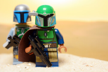 Fototapeta premium Lego Star Wars figures Bobba Fett and the Mandalorian Din Djarin on the desert planet Tatooine