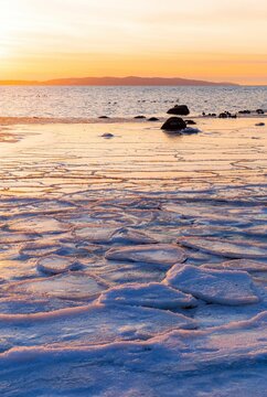 Vertical shot of a winter sunrise at a snowy beach