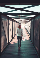 Obraz na płótnie Canvas Woman walking in modern tunnel with sunray
