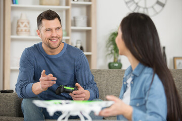 travelers couple using a drone at home