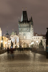 PRAGUE, CZECH - MARCH 12, 2016: Night Prague, Czech. Charles Karluv Bridge. Blurry People because of Long Exposure.
