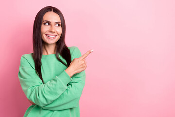 Photo of optimistic gorgeous woman straight hairdo dressed green sweatshirt look directing empty space isolated on pink color background