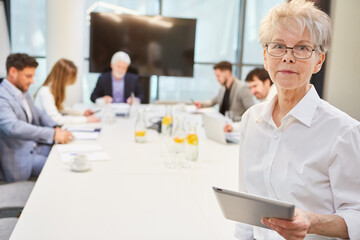 Ältere Geschäftsfrau mit Tablet Computer im Meeting
