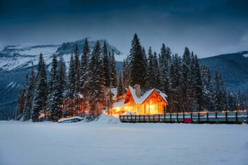 Emerald Lake with wooden lodge glowing in snowy pine forest on winter at Yoho national park