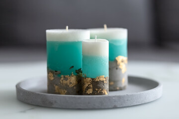 Decorative candles on a concrete base on a marble table in a room. Modern interior in the living room. Close-up. Photo