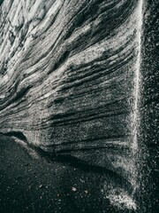 Greyscale of a rock formation with a small stream trickling down, Katla region of Iceland